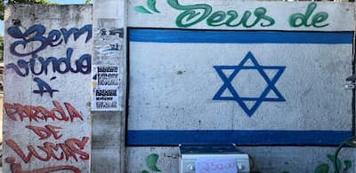 Muro no Complexo de Israel, comunidade do Rio de Janeiro onde traficantes associam práticas religiosas ao domínio territorial, misturando símbolos cristãos e judaicos à cultura do tráfico.